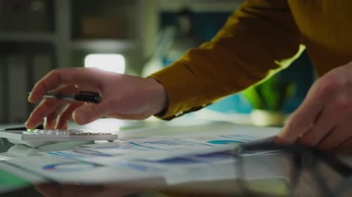 Close Up of Hands With Pen and Calculator