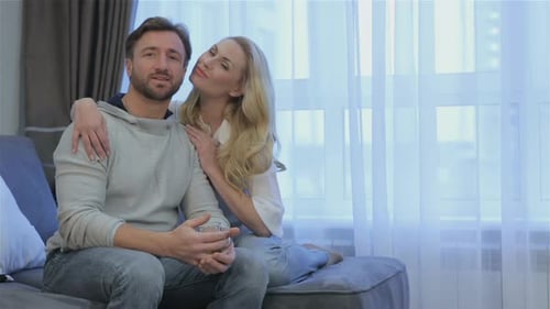 Couple Sits on the Couch at Home
