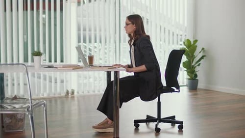 Office Manager Doing Forward Bend Stretch for Lumbar Spine in Corporate Fitness