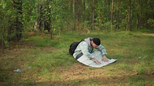 Traveler Studies Woodland Trail Map Person Inspects Map Amid Forest Surroundings Carefully Explorer