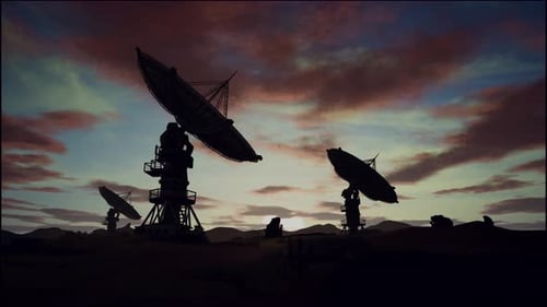 Satellite Dishes On Field Against Cloudy Sky During Sunset