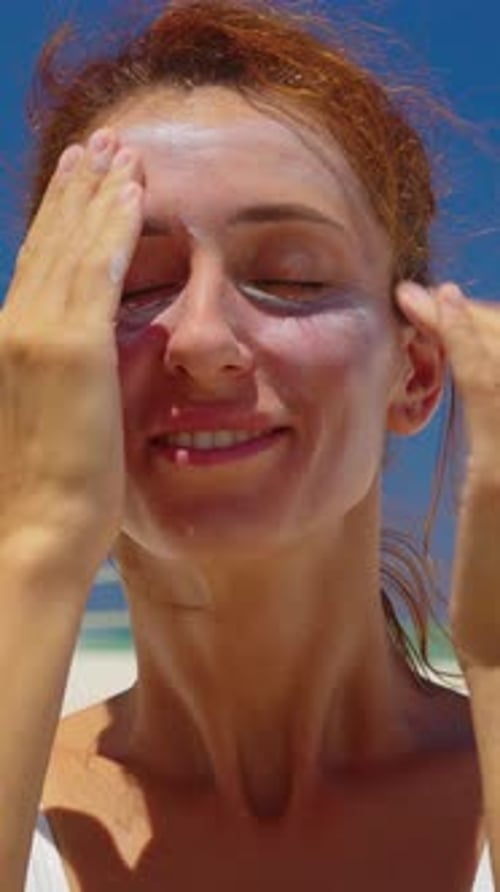 Vertical Video Closeup Beauty Portrait of Young Gorgeous Woman Applies Sun Cream on Her Face Enjoys