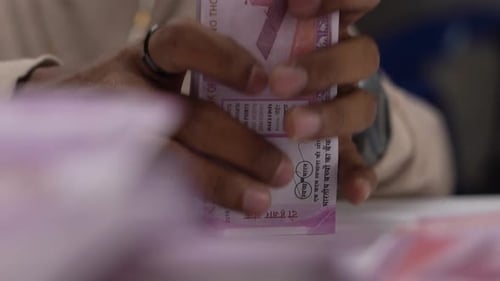 hands counting money Indian currency notes bundle