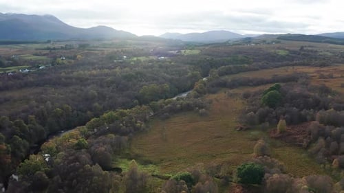 Vista aérea del serpenteante río y majestuosas montañas, Escocia.