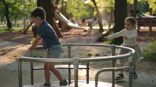 Kids Playing on a Merry-Go-Round at a Park
