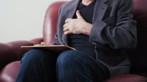 Senior Man Sitting on Couch Taking Notes
