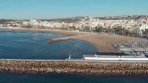 Vistas deslumbrantes da extensa cidade costeira a partir de um cais rochoso que se estende até o mar