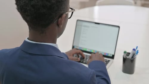 Overhead View of Young Businessman Working on Laptop