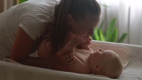 Loving Mother Playing with her Baby at Home