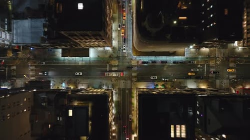 Cars Weaving Through a Lively Manhattan New York City Intersection at Night Highlighting Vibrant