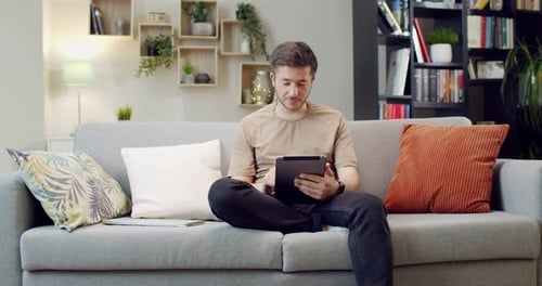 Man Relaxing at Home with a Tablet