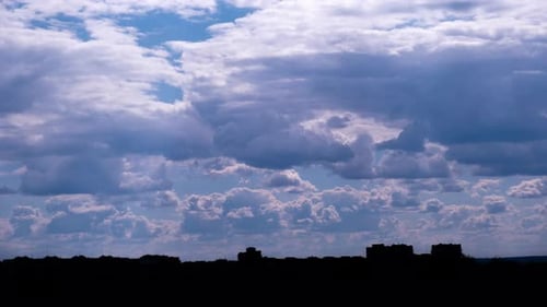 Timelapse of Cumulus Clouds Moving in the Blue Sky Over the City Horizon