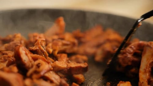 Chicken with curry sauce with smoke.slow motion. spatula turns the pieces of meat in the sauce close