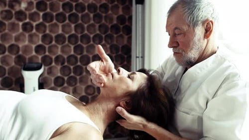 Senior Man Giving Woman Neck Massage in Clinic