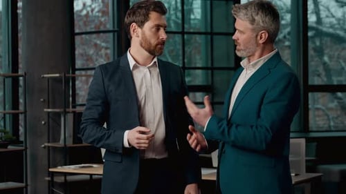 Two Adult Caucasian Businessmen Partners Discussing Business Deal in Office Professional Males Men