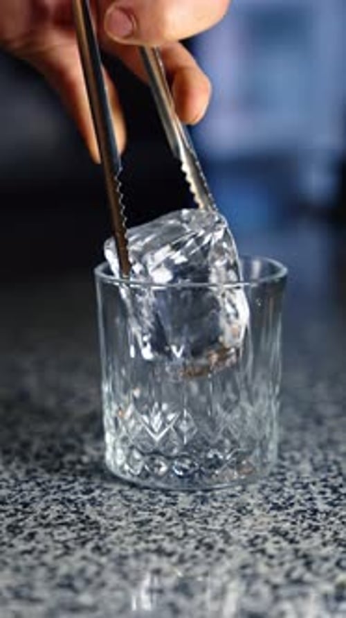 Ice Dropped into Decorative Glass for Refreshing Drink