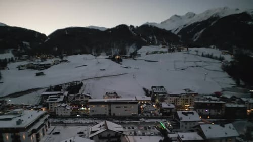 Night city lights on winter resort covered in snow, aerial view