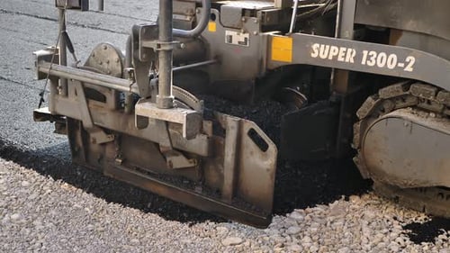 An Asphalt Spreader or an Asphalt Paver Machine on a Road Construction Site