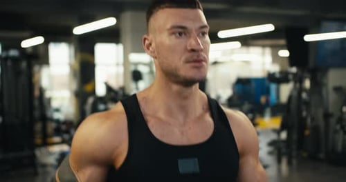 Portrait of a Young Athlete Jogging on a Treadmill Warm Up in the Gym