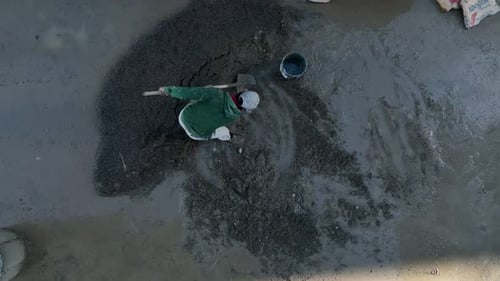 Construction Worker Mixing Cement with Shovel Aerial View