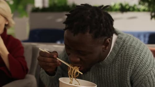 Diverse Employees Enjoying Lunch Break Conversation in Modern Office