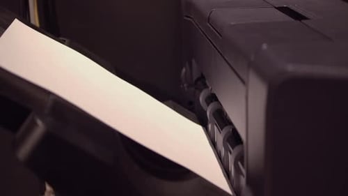 Four pieces of paper eject into collection tray from office printer