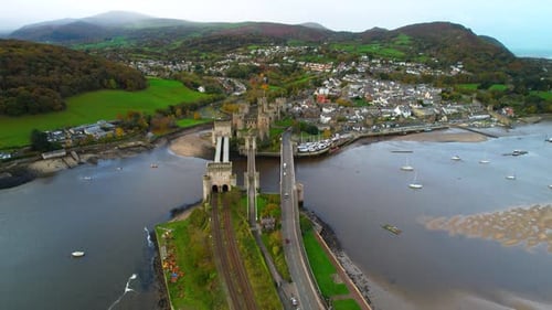 Drone flying over bridges of Conwy river estuary with castle in background, North Wales in UK. Aeria