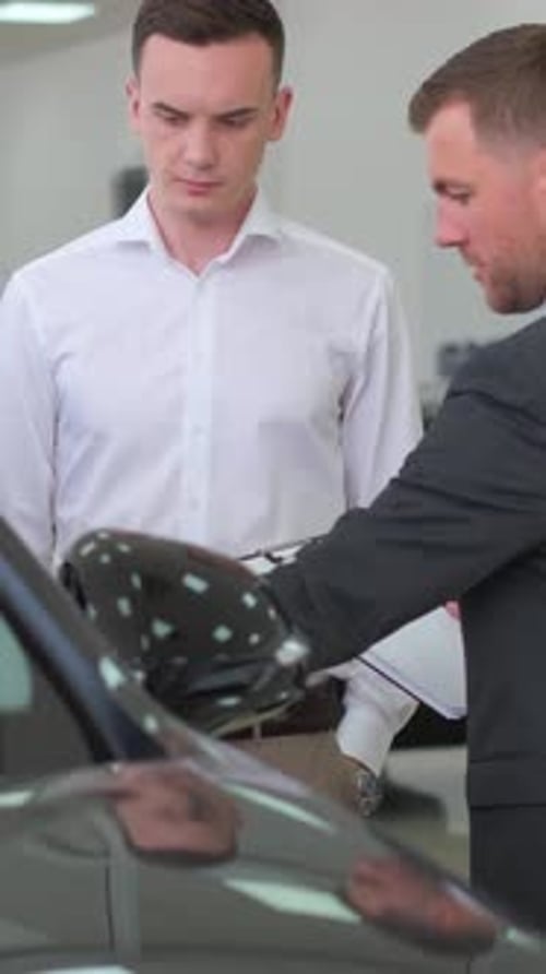 Young Adult Men Buying New Car at Dealership
