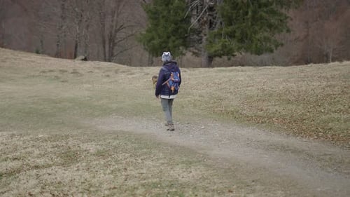 Person Hiking With Dog on Rural Path