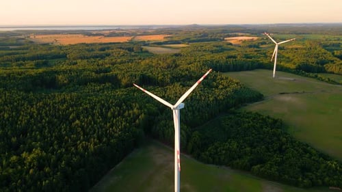 Aerial view of windmills farm for energy production on beautiful cloudy sky at highland. Wind power