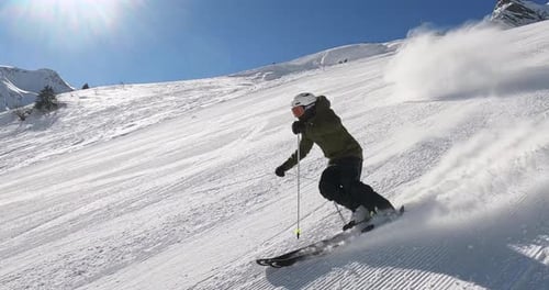 Professional male downhill skier skiing fast and sporty slalom ski turns on a perfect groomed ski sl