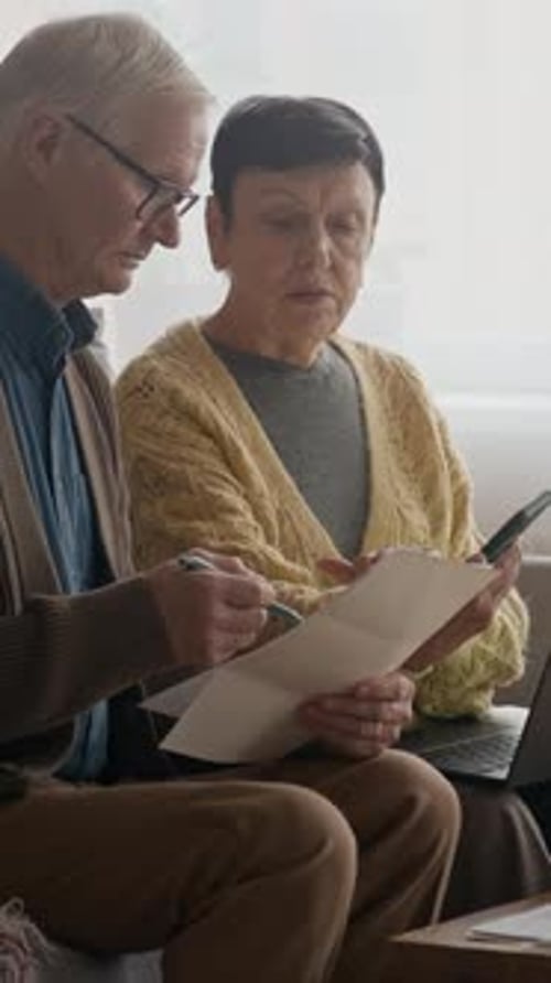Senior Couple Looking at Documents on Couch