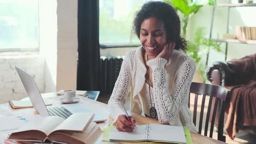 Woman with Curly Hair Smiling and Writing