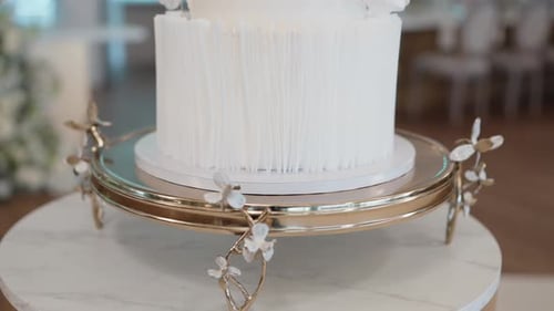modern white wedding cake on golden floral cake stand