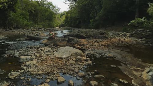 Flyover Model In Bikini On Rock In Jungle River In Costa Rica, 4K Drone