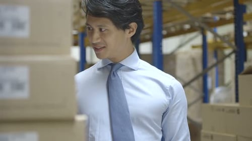 MS TU TD Man standing and using digital tablet in warehouse