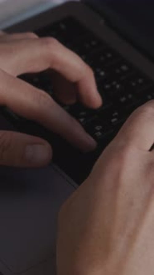 Close Up of Man's Hands Typing on Laptop