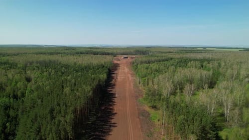 Aerial View of Highway with Trucks and New Road Construction in Forest