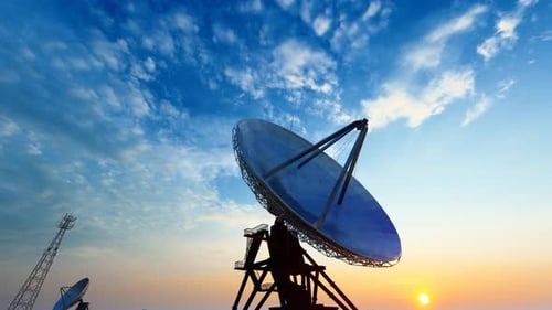 Communication Towers and Satellite Dishes Against Sunset Sky