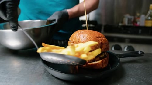 Delicious Burger with French Fries Being Plated