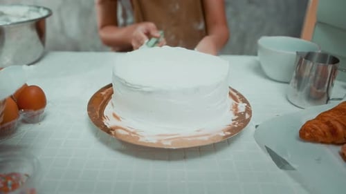 Child Frosting Cake at Kitchen Table