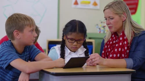 Teacher and Students Using Digital Tablet in School Classroom Asian