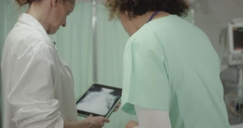 Doctor and Nurse in Hospital Emergency Room Discussing Patient Xray