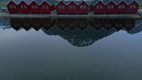 Scenic Red Cabins Reflected in Calm Mountain Lake