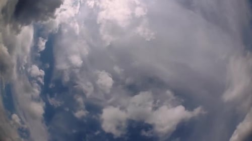 Blue sky and layer of clouds moving about in a fine sunny afternoon; time-lapse of clouds with diffe