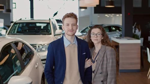Portrait of Young Caucasian Married Couple in Car Showroom