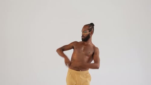 Shirtless Gay Man with Bright Makeup Dancing on White Background