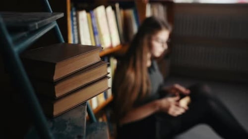 Young Woman Reading a Book in Library