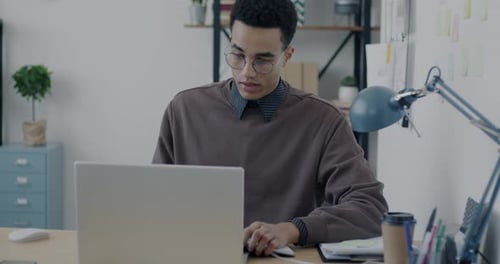 Young Adult Working at Desk on Laptop