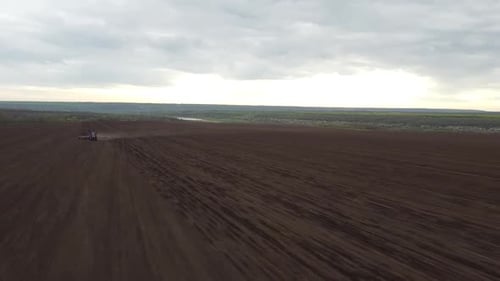 Blue tractor OA working on the field in Ukraine